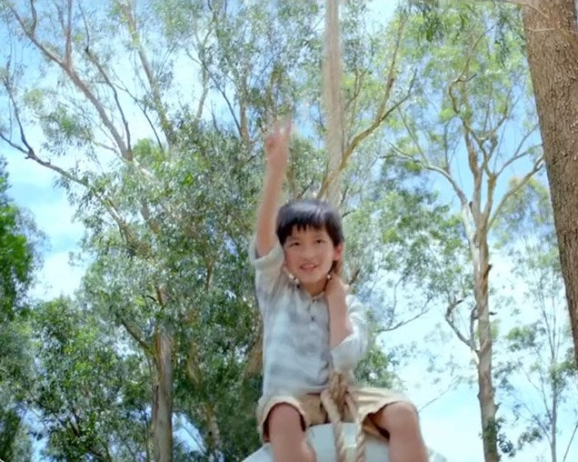 A child cheering from a tree, from our children's series TV ad
